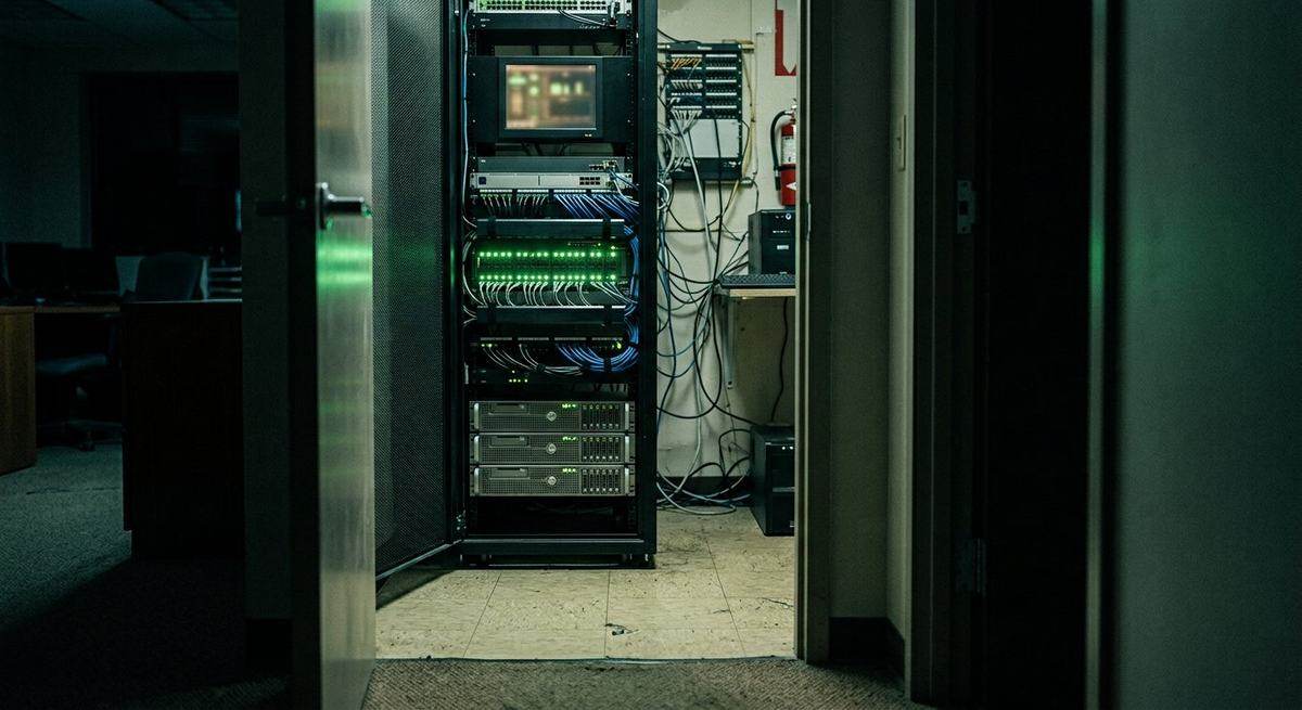 A server rack with green LEDs in a small office closet